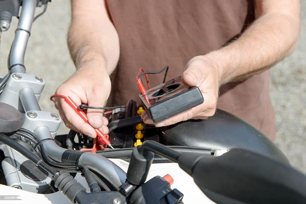 Man changing dead motorcycle battery